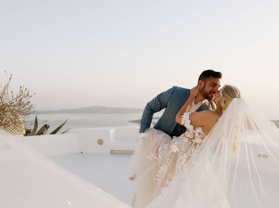 Santorini elopement in Dana Villas with gound fireworks, rose petals, cake cutting in Firostefani